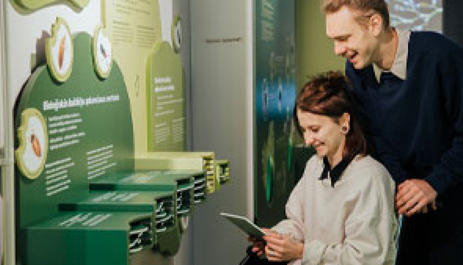 2 cilvēki pie interaktīva stenda par augiem