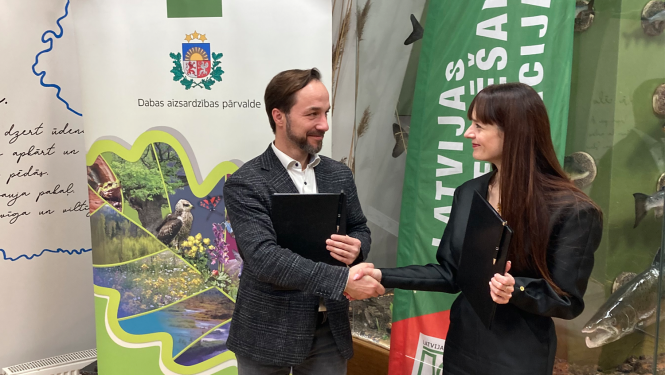 Latvijas orientēšanās federācijas prezidents Juris Žilko un Dabas aizsardzības pārvaldes ģenerāldirektore Laura Anteina paraksta sadarbības memorandu.