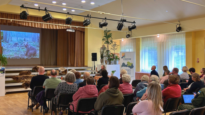 Semināra 'Kā sadzīvot ar lāci" dalībnieki vēro prezentāciju.