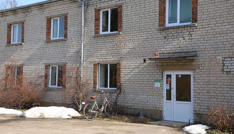 Divu stāvu, baltu silikāta ķieģeļu ēka. 