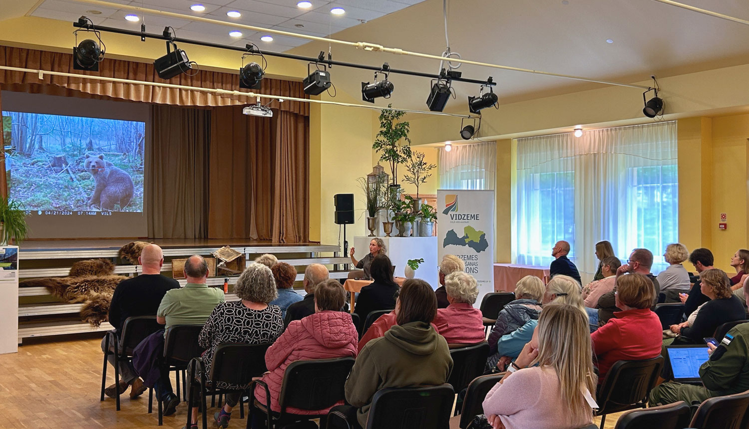Semināra 'Kā sadzīvot ar lāci" dalībnieki vēro prezentāciju.